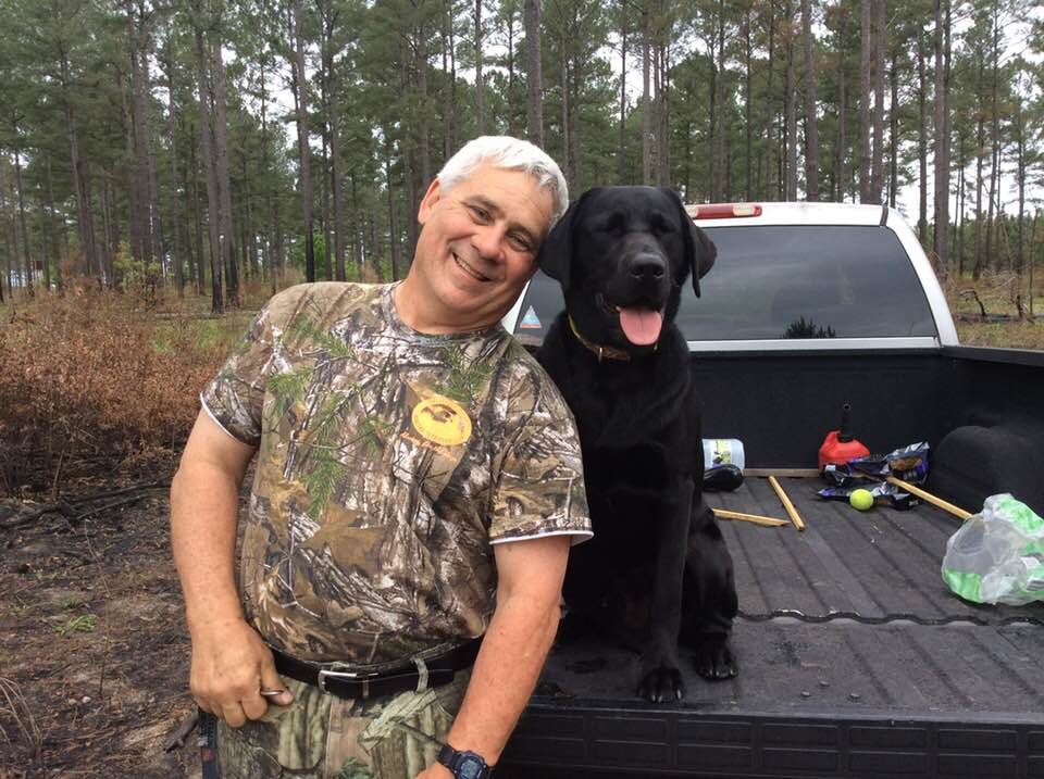 Mike Davis, left, smiles with his dog SHR Maximus Aurelis Davis after the Davis earned four ribbons in two days to get Max a Hunt Retriever title. Max is a one year old Black Labrador.